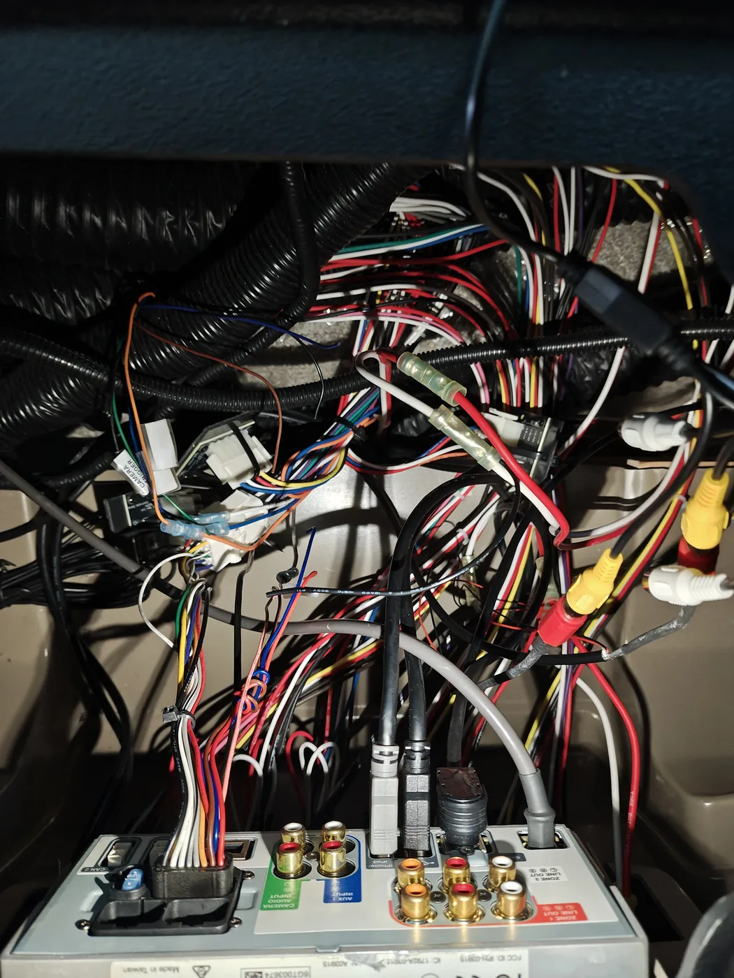 The rat's nest of wiring and RCA connectors behind the Garmin navigation system